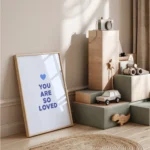 Nursery decor with toys and inspirational 'You Are So Loved' blue print quote