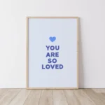 Timber framed blue print with 'You Are So Loved' message on floorboards