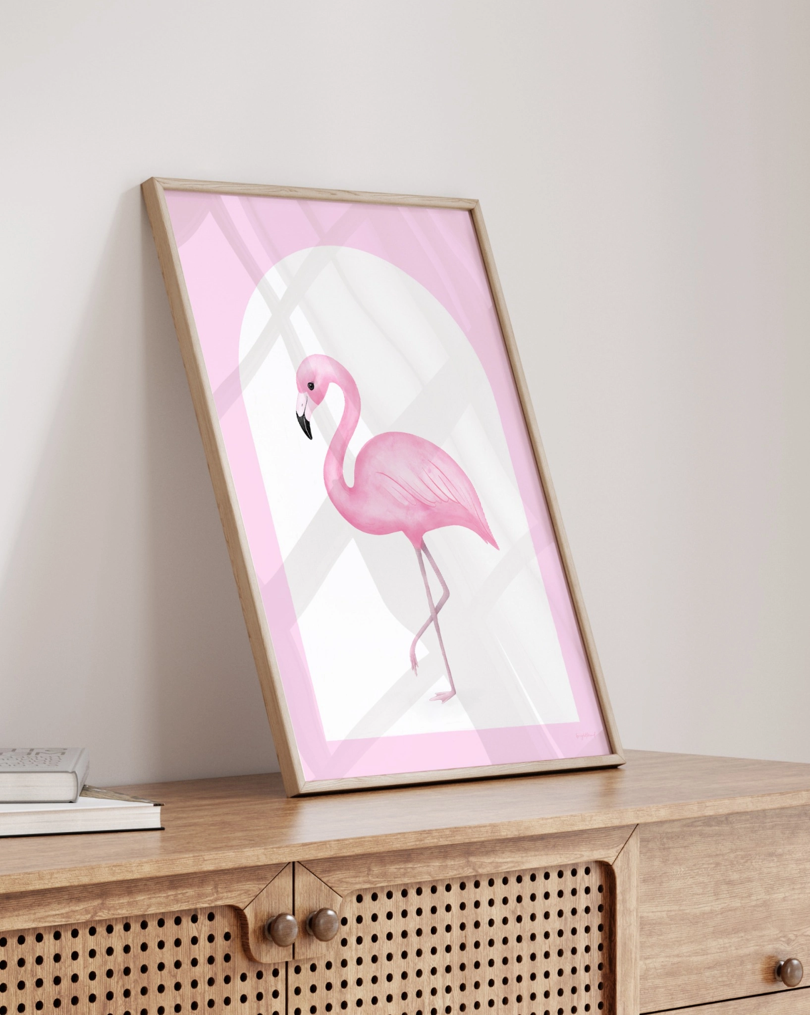 Framed pink flamingo art on wooden dresser